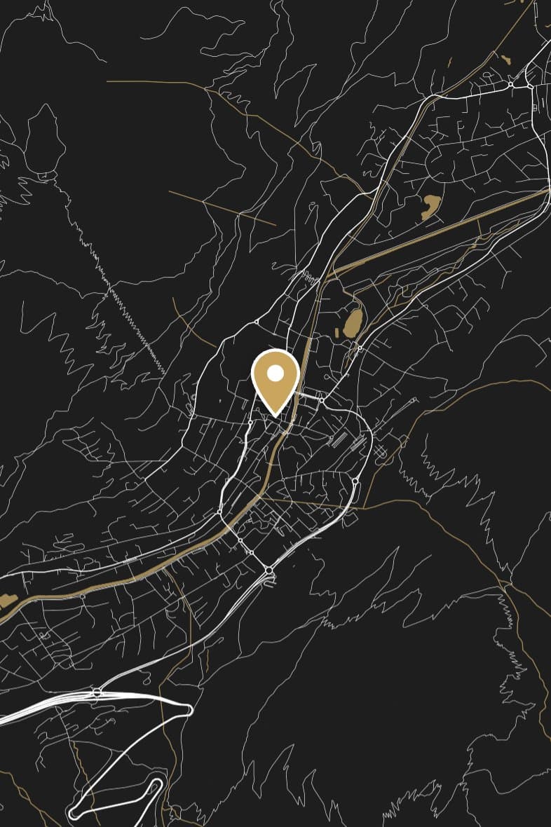 Chamonix's streets drawn in white on black in a narrow valley, with the river in gold and a gold pin in the town.